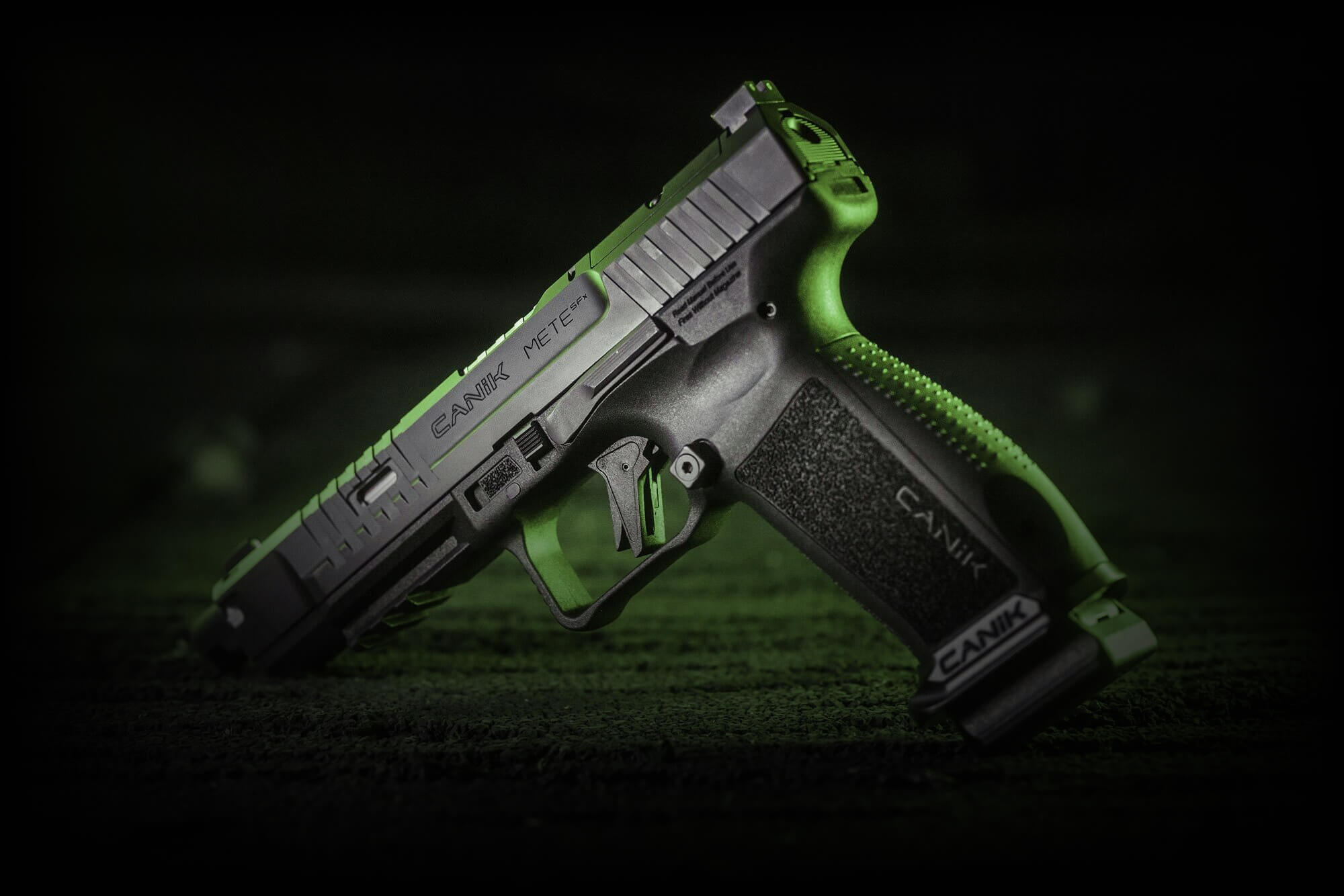 Pistolet Canik prezentowany na na drewnianym tle z amunicją w tle